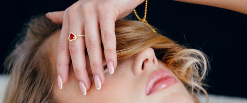 Loretana model dramatic side pose with ruby earring and gold chain layered necklace, multiple piercings styling. Hallmarked Kaunas.