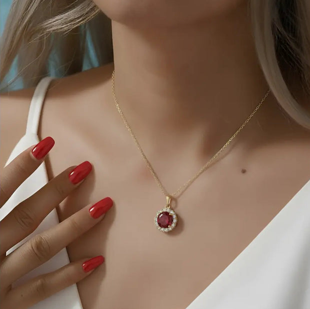 Close up of the 14K Gold Ruby Halo Necklace highlighting the precision-cut ruby AAAAA zirconia and the high-polish 14K gold-plated setting.