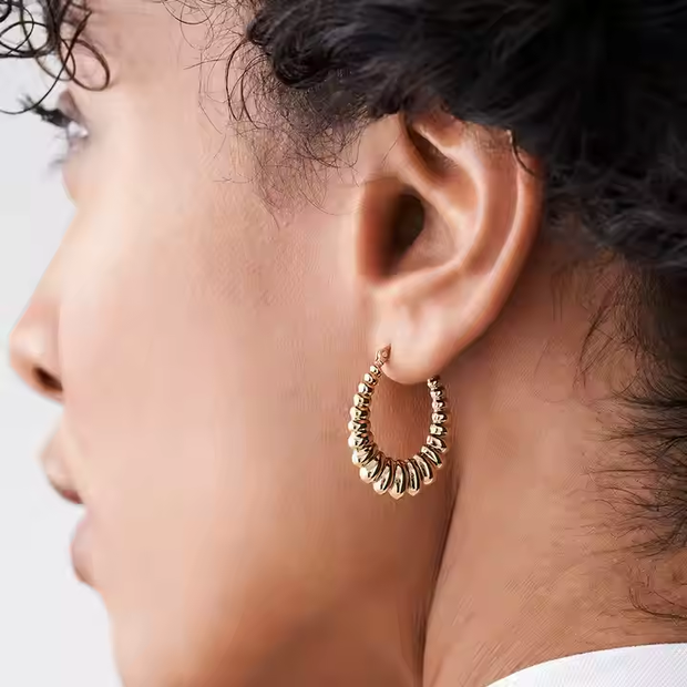 Artimas 14K aukso storų susuktų lankų vaizdas, pabrėžiantis ritmišką sukimą ir blizgančią 14K aukso apdailą.