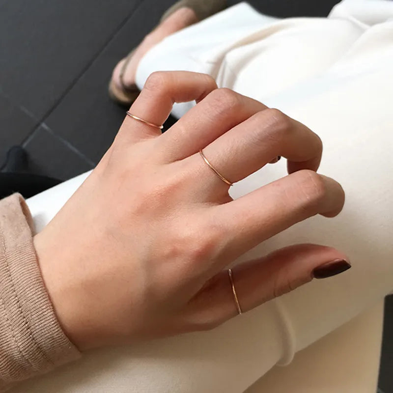 Close-up of a woman's hand wearing multiple 14k gold plated