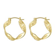 A profile view of a model wearing the sculptural 14K gold-plated irregular wavy hoop earrings.