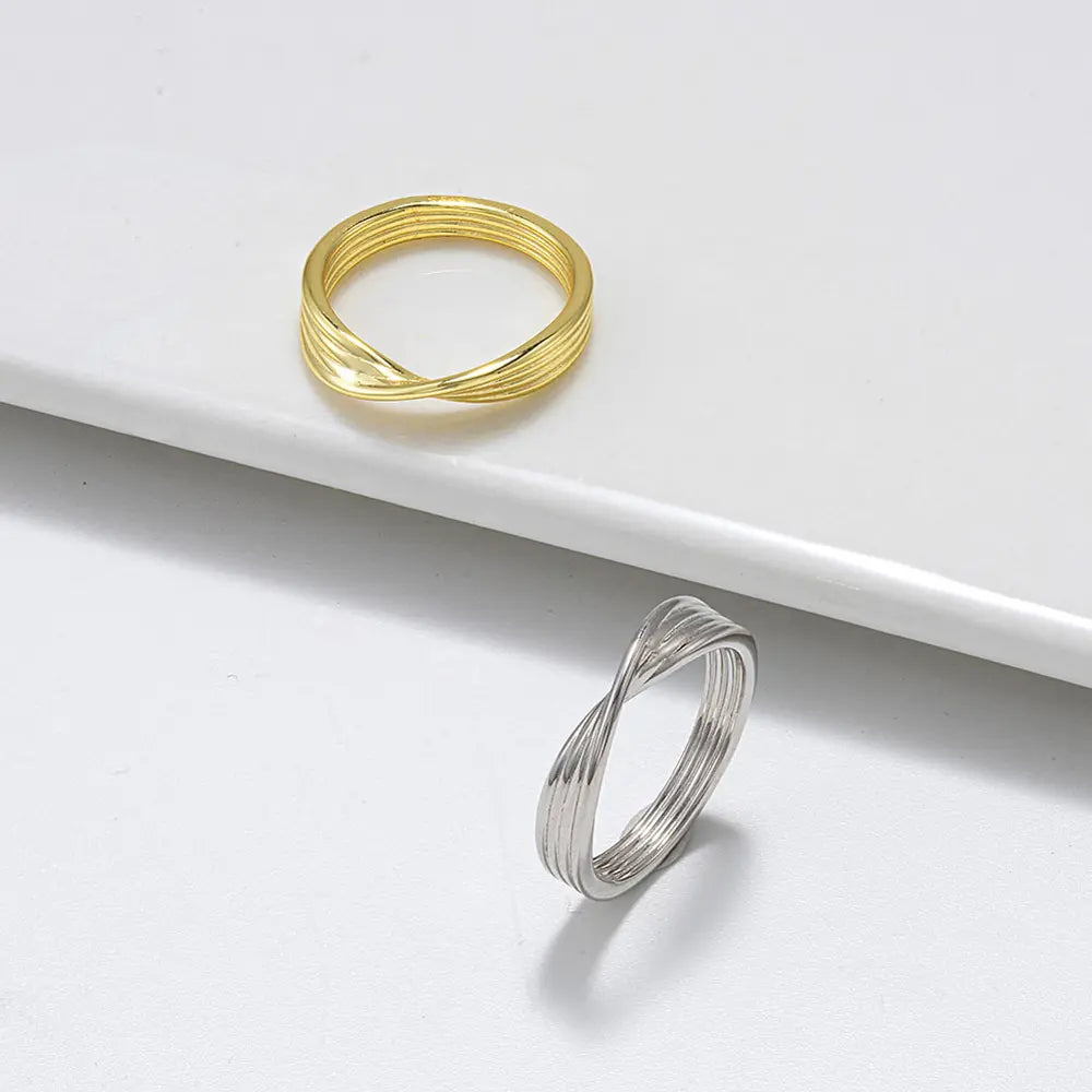Profilio vaizdas, kuriame modelis dėvi minimalistinį 14K aukso susuktą mazgo žiedą.