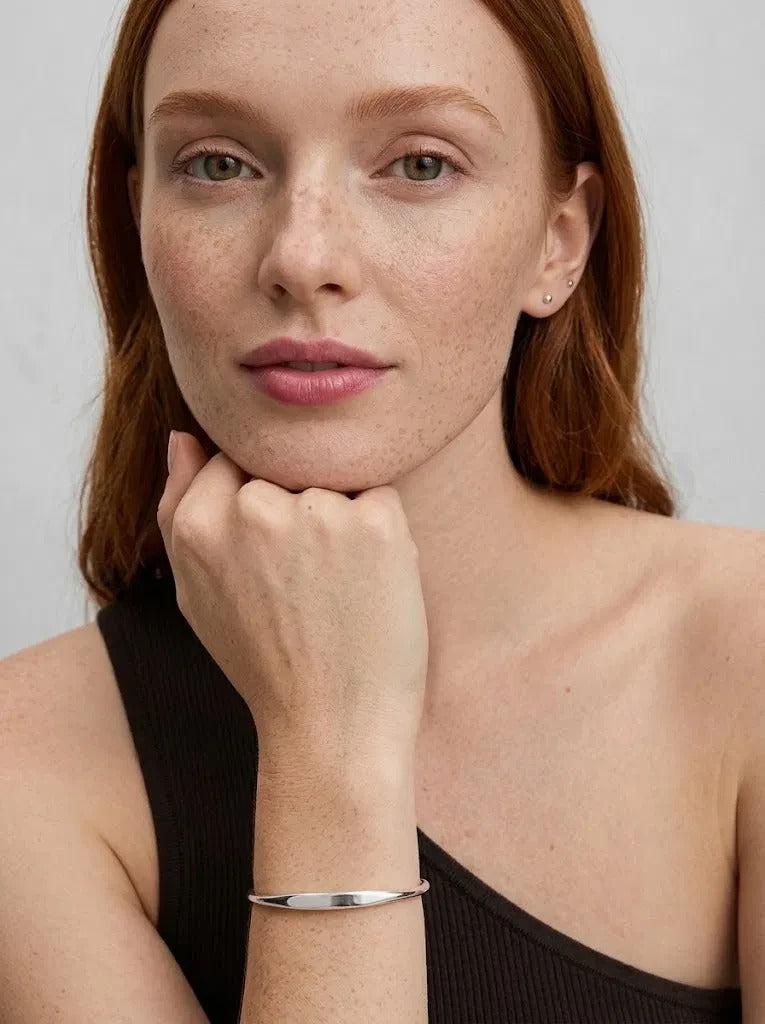 Woman resting her chin on her hand, wearing the 925 silver Personalized Letter Bangle