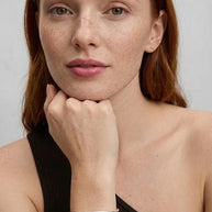 Woman resting her chin on her hand, wearing the 925 silver Personalized Letter Bangle