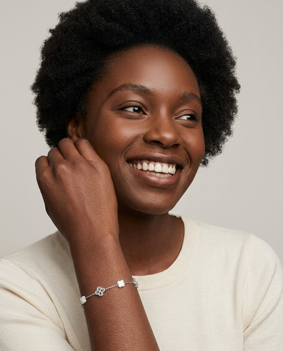 Smiling woman wearing the 925 silver Clover Shell Pearl Bracelet with white shell clovers and filigree silver clovers