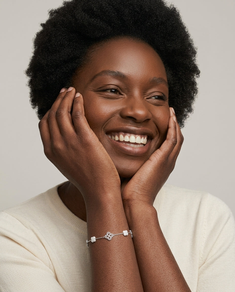 Laughing woman with hands on her face wearing the silver Clover Shell Pearl Bracelet on her wrist