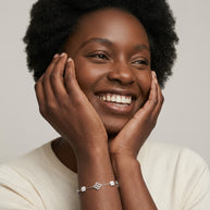 Laughing woman with hands on her face wearing the silver Clover Shell Pearl Bracelet on her wrist