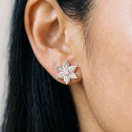 Close-up of Loretana 925 silver flower stud earring with CZ stones on the earlobe