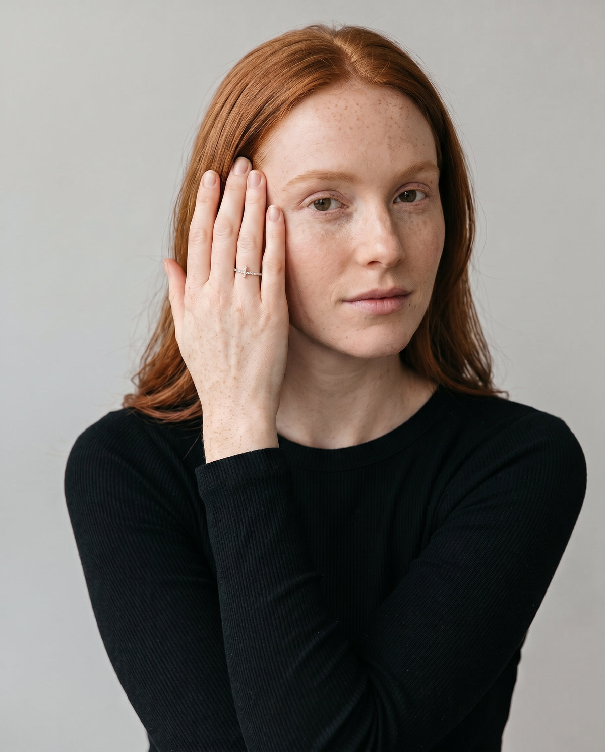 Loretana R31-S silver pave cross ring worn by model, hand at temple