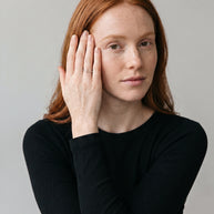 Loretana R31-S silver pave cross ring worn by model, hand at temple