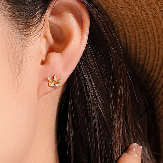 Close up of architectural gold crown stud earrings showing precision zirconia setting