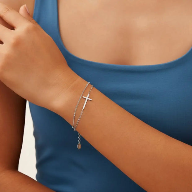 Close up of 925 silver layered bracelet showing minimalist cross pendant and dual chain design