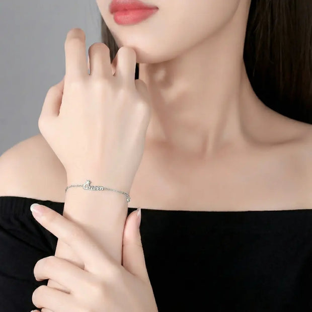 Close up of 925 silver bracelet showing custom initial and minimalist crown pendant