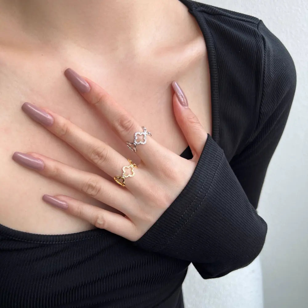 Close-up of a woman's hand wearing the 925 silver Bloom clover ring for a modern, botanical look.