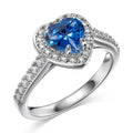 Macro detail of the heart-cut deep blue AAAAA cubic zirconia in the rhodium-plated 925 silver ring's prong setting.