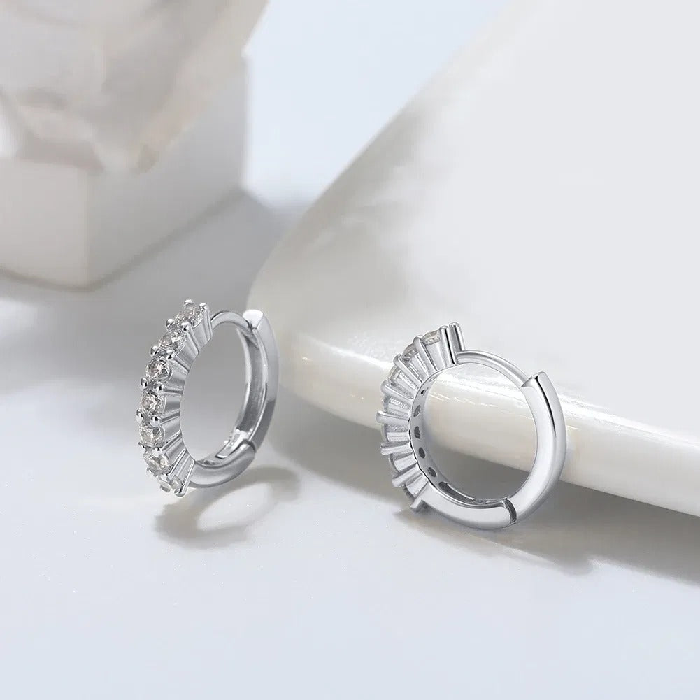 925 silver round hoops on white marble, a row of prong-set cubic zirconia.