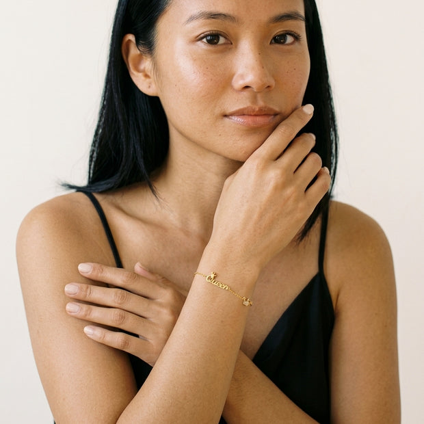 Model wearing the Crown Initial Bracelet in 14K gold-plated 925 sterling silver
