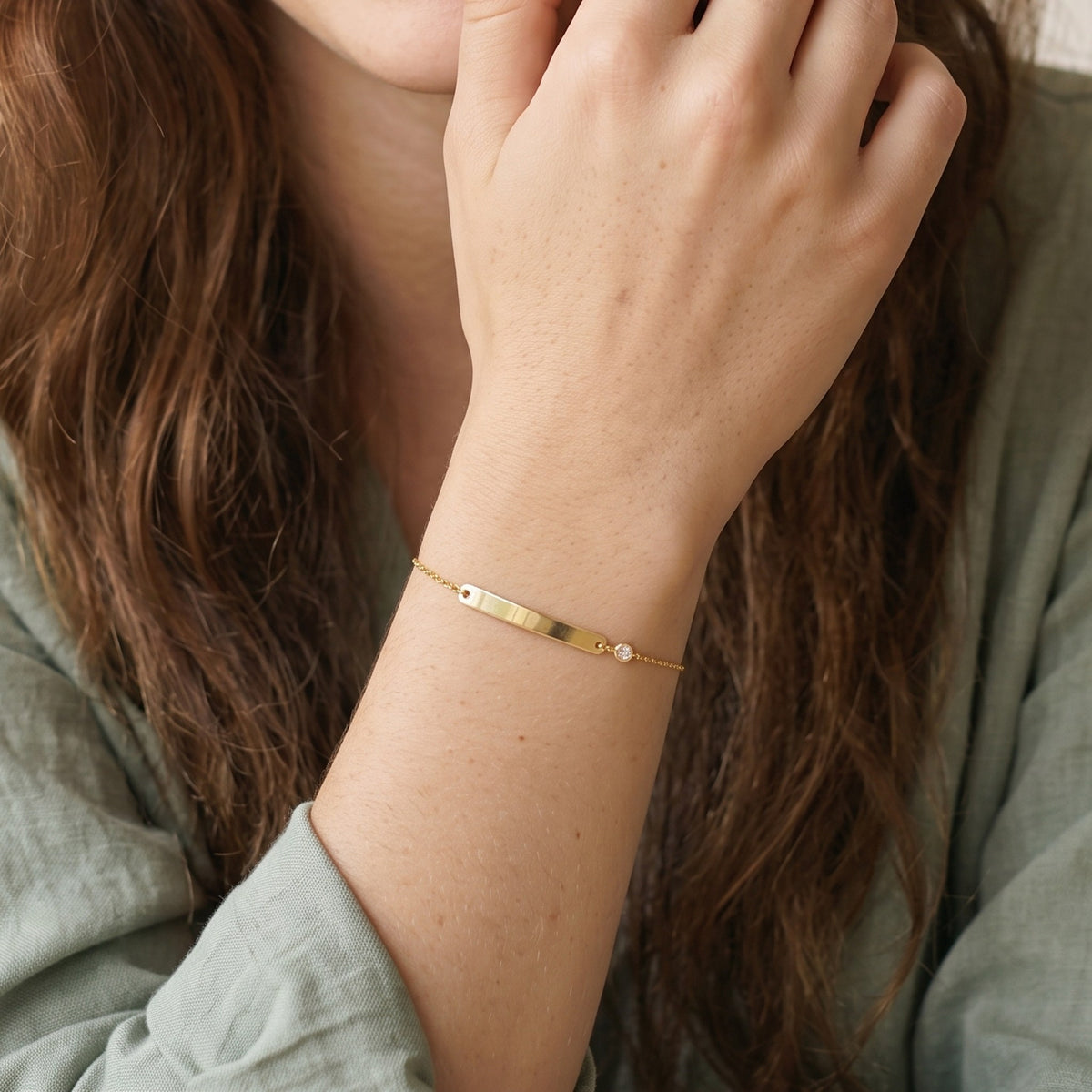 Close-up of the Engraved Curved Bar Bracelet, CZ in 14K gold-plated 925 sterling silver, worn