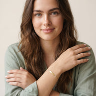 Model wearing the Engraved Curved Bar Bracelet, CZ in 14K gold-plated 925 sterling silver