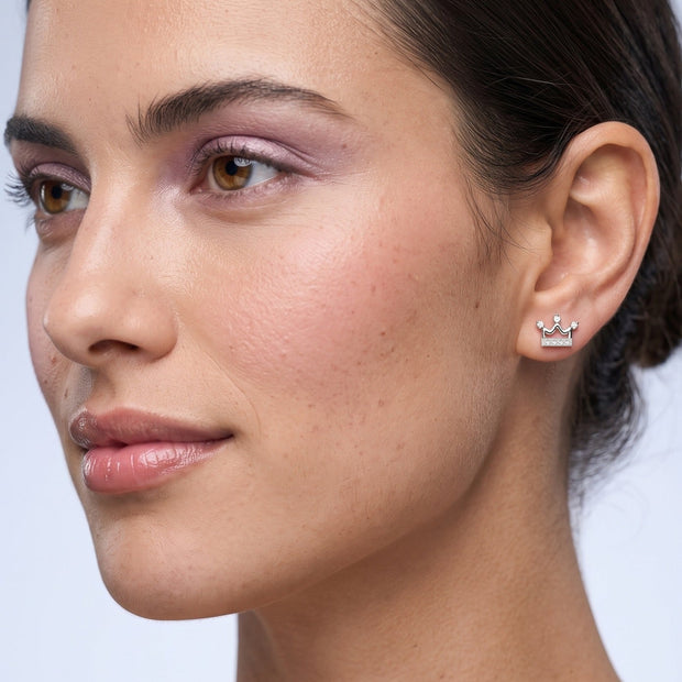 Silver crown stud earring with cubic zirconia worn on the ear