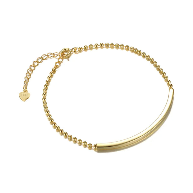 Woman wearing 14K gold engraved curved bar bracelet as a personalized fine jewelry piece