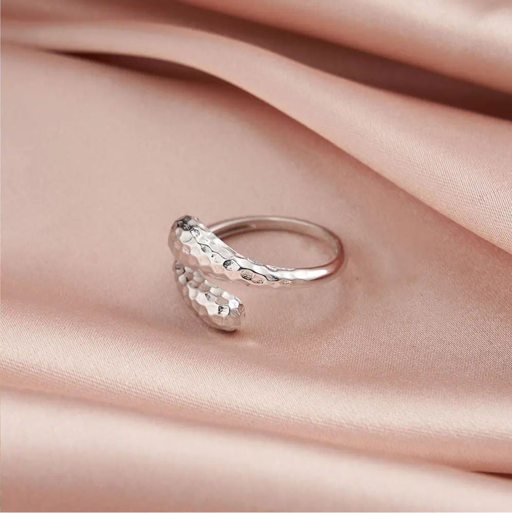 Close-up of a woman's hand wearing the 925 silver snake and teardrop adjustable rings together.