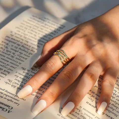 Close-up of the gold twisted wave ring highlighting the open-back adjustable 925 sterling silver band.
