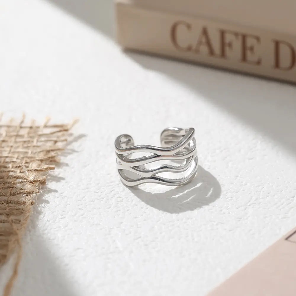 Close-up of a woman's hand wearing the 925 silver twisted wave adjustable ring for a minimalist look.
