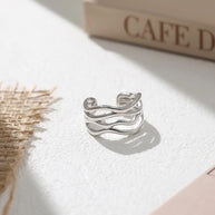 Close-up of a woman's hand wearing the 925 silver twisted wave adjustable ring for a minimalist look.
